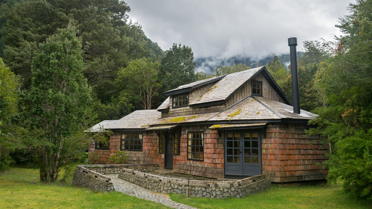 Auf diesem Bild ist ein ländliches Haus abgebildet, umgeben von grünen Wiesen und idyllischer Natur, das eine ruhige und friedliche Atmosphäre ausstrahlt