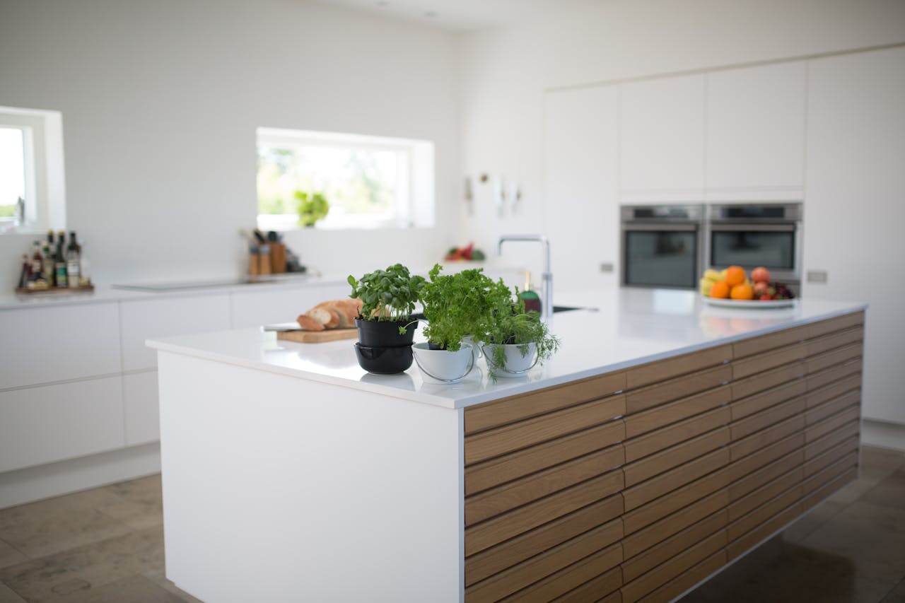 Auf diesem Bild ist eine moderne Küche mit einer Kochinsel zu sehen, die einen stilvollen und funktionalen Raum zum Kochen und Zubereiten von Mahlzeiten bietet